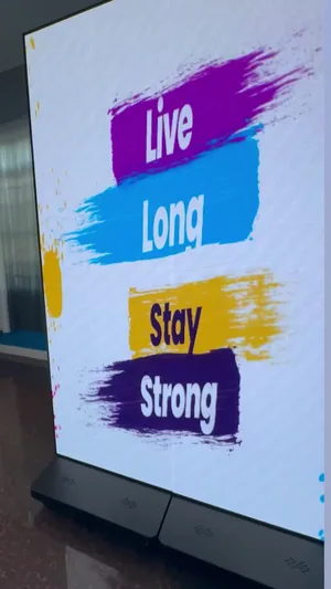 A Timesquare P2.5 LED panel on its base indoors, showing Live Long Stay Strong creative