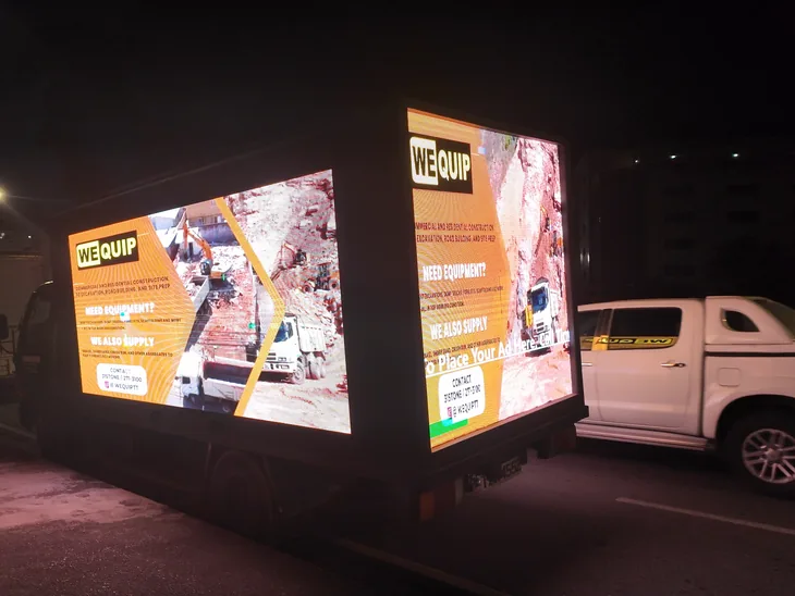 Timesquare LED truck at night on CPL 2026 match night with both side screens lit, running a WeQuip equipment ad